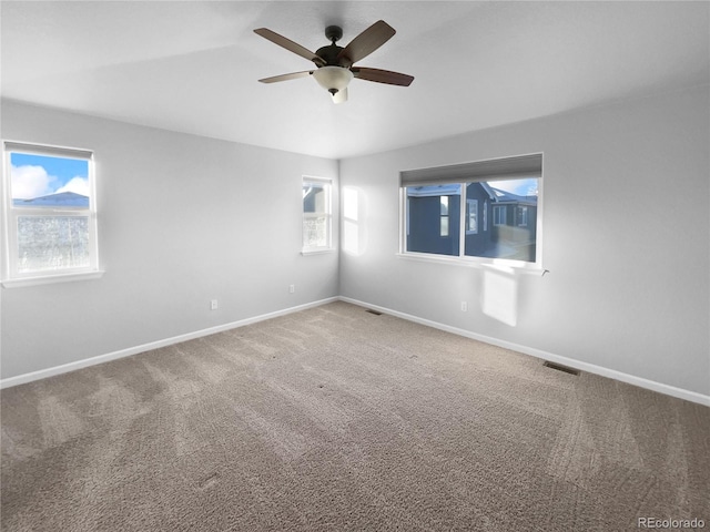 carpeted spare room with ceiling fan