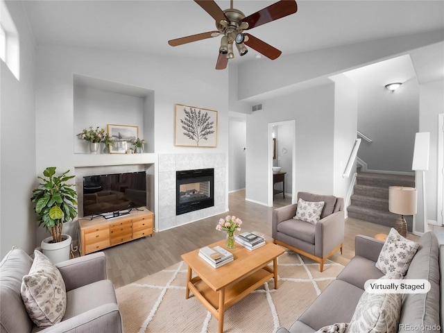 living room with hardwood / wood-style floors, ceiling fan, a fireplace, and vaulted ceiling