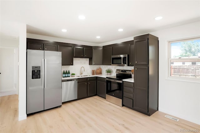 5554 Crystal Way, Denver, CO 80239 - kitchen featuring appliances with stainless steel finishes, light wood-type flooring, light countertops, tasteful backsplash, and recessed lighting