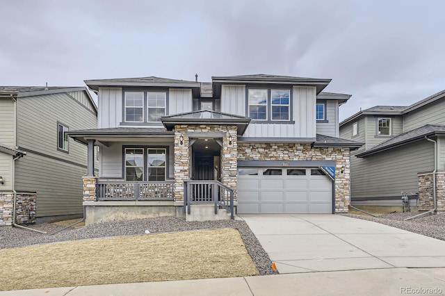 15153 W Dequesne Ave, Morrison, CO 80465 - view of front of home with stone siding, concrete driveway, board and batten siding, a porch, and an attached garage