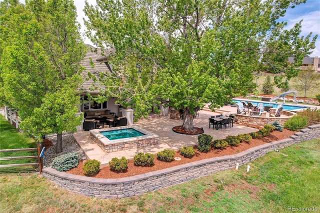 outdoor pool featuring an in-ground hot tub, a water slide, a patio, and fence