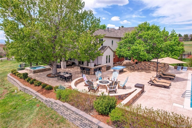 view of patio featuring a hot tub, an outdoor living space with a fire pit, and outdoor dining area