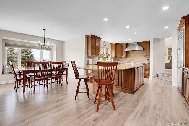 kitchen with tasteful backsplash, recessed lighting, light wood finished floors, brown cabinets, and baseboards