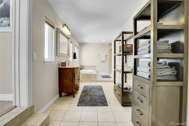 bathroom with a bath, tile patterned flooring, vanity, baseboards, and recessed lighting