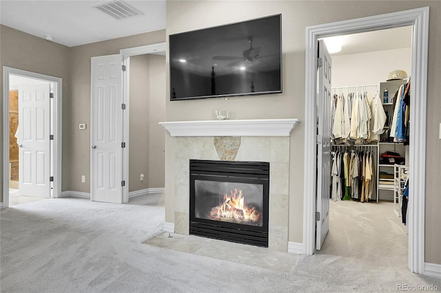 unfurnished living room featuring carpet flooring, a tiled fireplace, a ceiling fan, and baseboards
