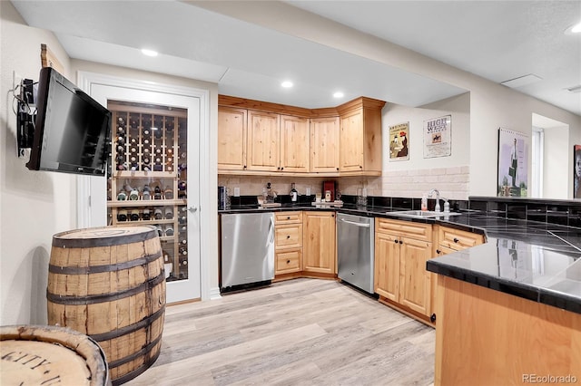 kitchen with stainless steel dishwasher, light brown cabinetry, dark countertops, light wood-type flooring, and recessed lighting