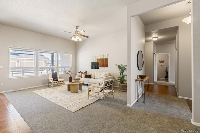 living area featuring carpet floors, a ceiling fan, and baseboards