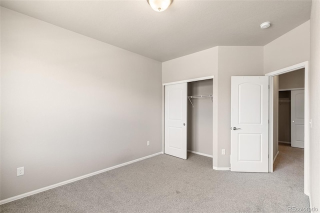 unfurnished bedroom featuring baseboards, carpet floors, and a closet