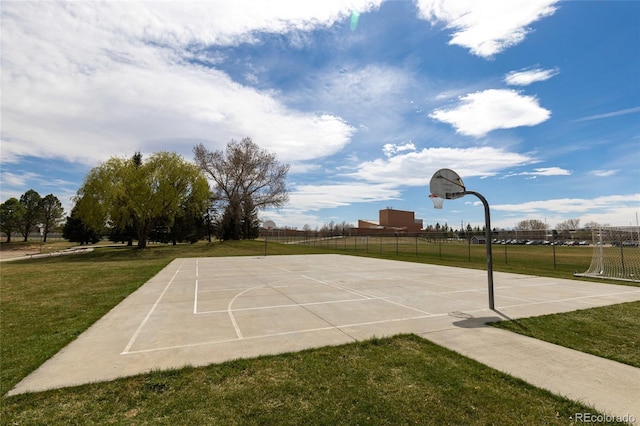 view of basketball court featuring fence, a lawn, and community basketball court