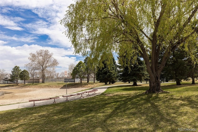 view of property's community with fence and a lawn