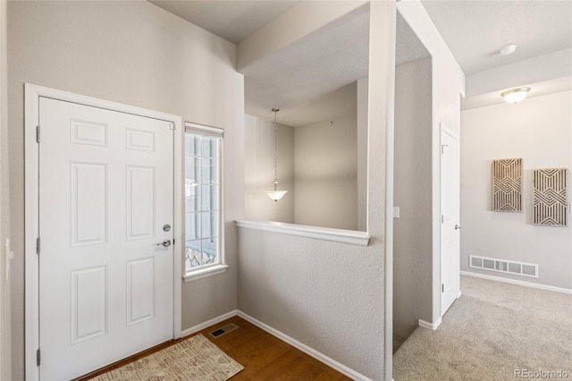 foyer entrance featuring visible vents and baseboards