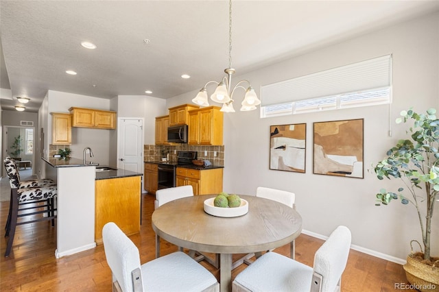 dining space with baseboards, an inviting chandelier, wood finished floors, and recessed lighting