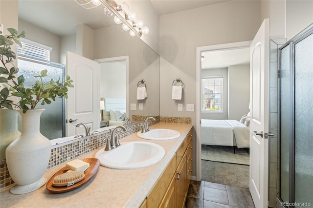 ensuite bathroom featuring connected bathroom, tile patterned floors, a sink, and double vanity