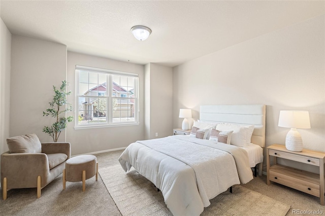 bedroom featuring baseboards and light colored carpet