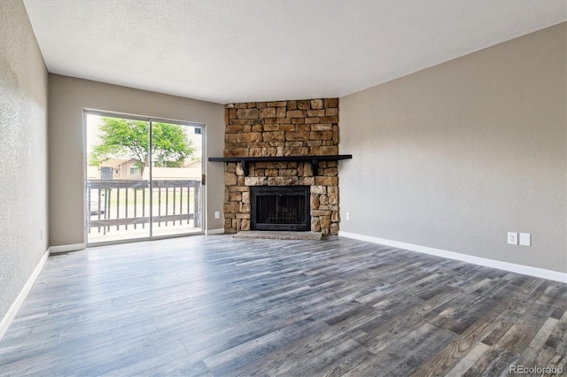 1777 S Pitkin St Unit A, Aurora, CO 80017 - unfurnished living room featuring wood finished floors, a stone fireplace, and a textured wall