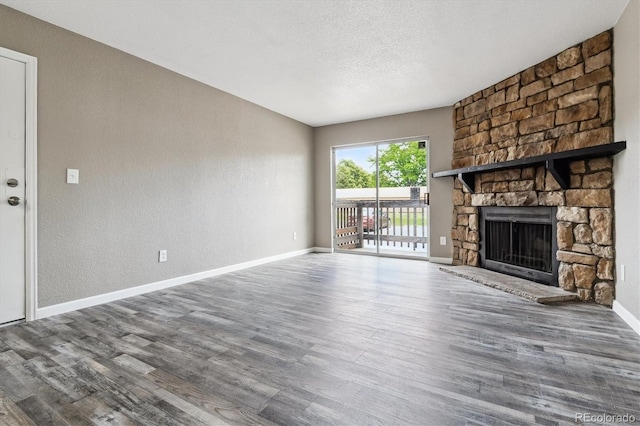 1777 S Pitkin St Unit A, Aurora, CO 80017 - unfurnished living room featuring wood finished floors, a fireplace, a textured wall, and a textured ceiling