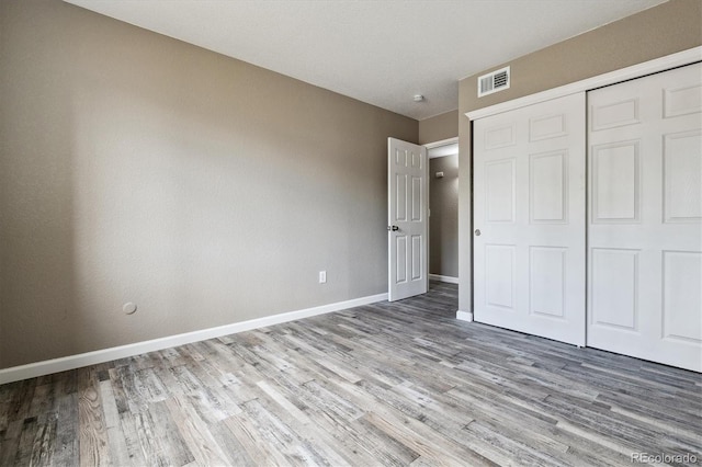 1777 S Pitkin St Unit A, Aurora, CO 80017 - unfurnished bedroom featuring wood finished floors and a closet