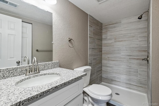1777 S Pitkin St Unit A, Aurora, CO 80017 - full bathroom with a textured wall, vanity, a textured ceiling, and a tile shower