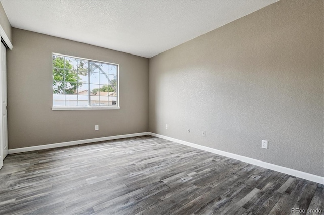 1777 S Pitkin St Unit A, Aurora, CO 80017 - spare room with dark wood-type flooring, a textured wall, and a textured ceiling
