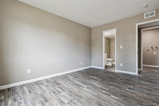 1777 S Pitkin St Unit A, Aurora, CO 80017 - unfurnished bedroom featuring dark wood-style floors and connected bathroom