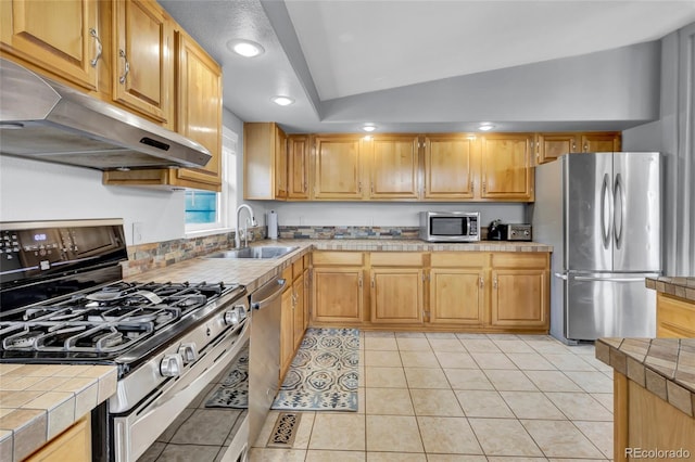 248 Copperdale Ln, Golden, CO 80403 - kitchen with stainless steel appliances, under cabinet range hood, tile countertops, light tile patterned floors, and recessed lighting