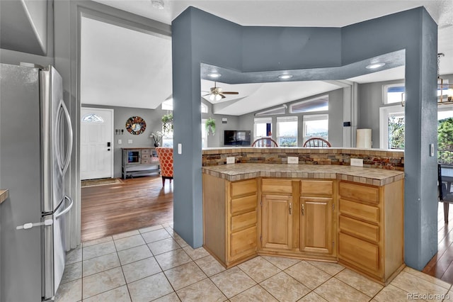 248 Copperdale Ln, Golden, CO 80403 - kitchen with freestanding refrigerator, ceiling fan, lofted ceiling, and light tile patterned flooring