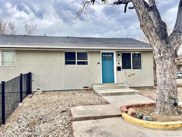 view of front of property featuring crawl space, roof with shingles, fence, and stucco siding