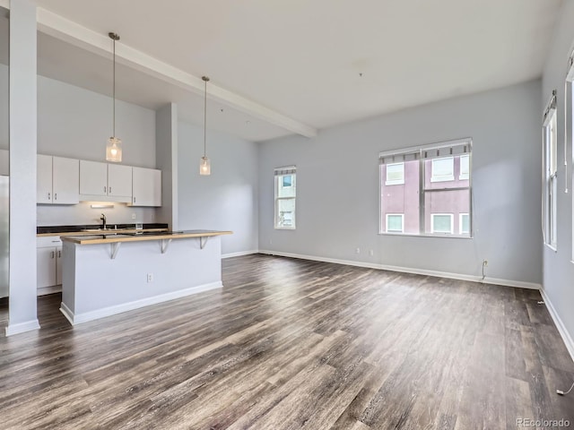 2501 15th St Unit 3D, Denver, CO 80211 - unfurnished living room featuring dark wood finished floors, a sink, baseboards, and beam ceiling