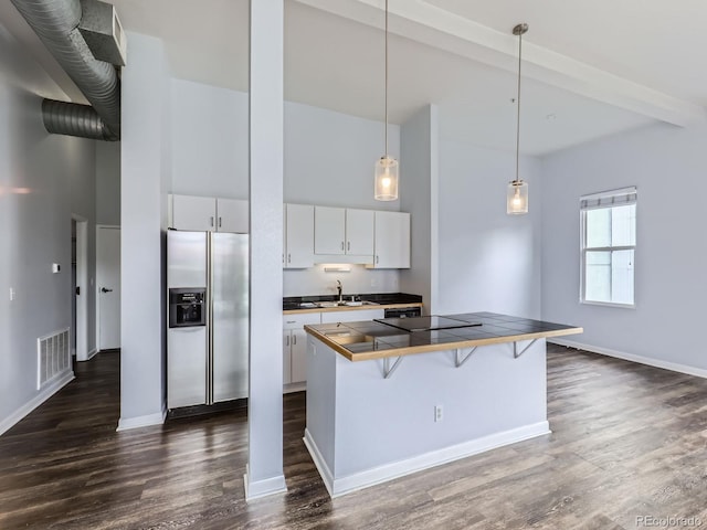 2501 15th St Unit 3D, Denver, CO 80211 - kitchen with stainless steel fridge, high vaulted ceiling, a breakfast bar area, white cabinetry, and baseboards