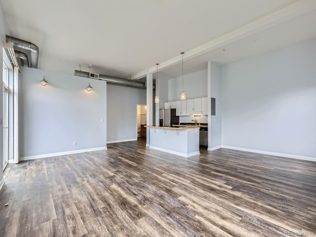 2501 15th St Unit 3D, Denver, CO 80211 - unfurnished living room with a sink, dark wood finished floors, baseboards, and a towering ceiling