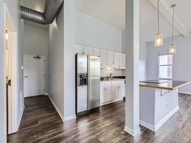 2501 15th St Unit 3D, Denver, CO 80211 - kitchen with stainless steel fridge, high vaulted ceiling, dark wood-type flooring, white cabinets, and baseboards