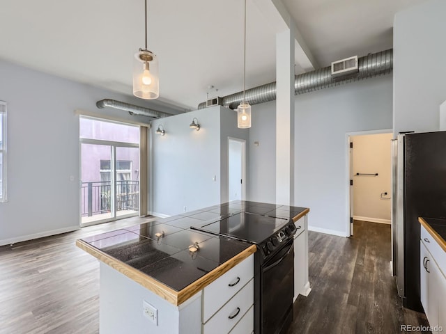 2501 15th St Unit 3D, Denver, CO 80211 - kitchen with black electric range, freestanding refrigerator, dark wood-style flooring, tile countertops, and white cabinetry