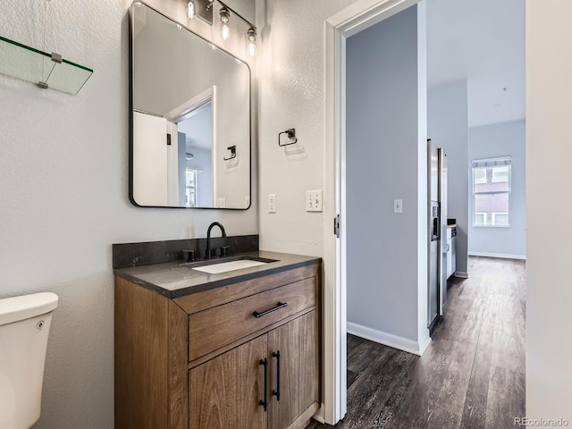 2501 15th St Unit 3D, Denver, CO 80211 - bathroom featuring vanity, wood finished floors, toilet, and baseboards