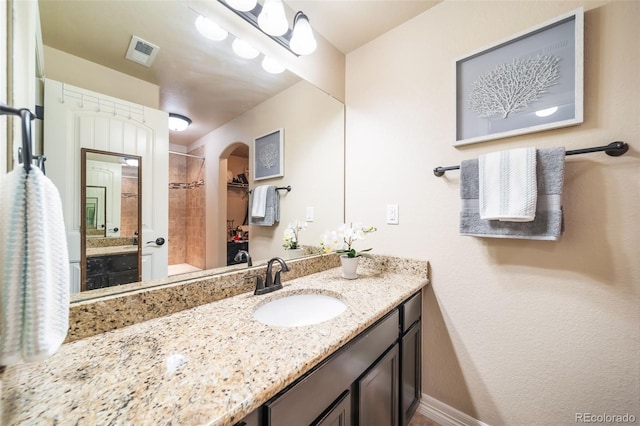 bathroom with vanity and tiled shower