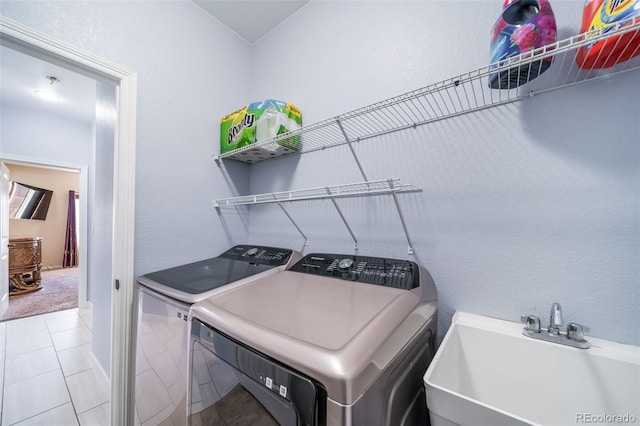 laundry area featuring sink, light colored carpet, and washing machine and dryer