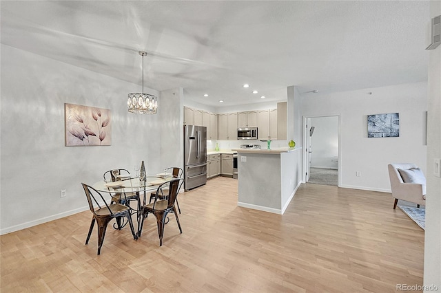 dining area with light hardwood / wood-style floors and an inviting chandelier