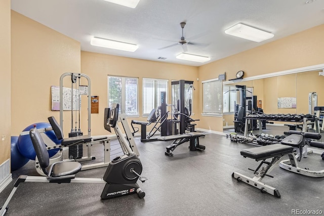 gym with ceiling fan and a textured ceiling