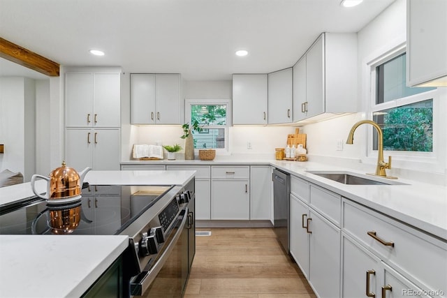 1815 Ingalls St, Lakewood, CO 80214 - kitchen with a sink, stainless steel appliances, light countertops, recessed lighting, and white cabinets