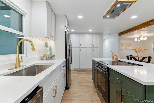 1815 Ingalls St, Lakewood, CO 80214 - kitchen featuring stainless steel appliances, a sink, green cabinetry, light wood-type flooring, and white cabinets