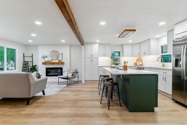 1815 Ingalls St, Lakewood, CO 80214 - kitchen featuring stainless steel refrigerator with ice dispenser, light countertops, a kitchen island, white cabinets, and recessed lighting