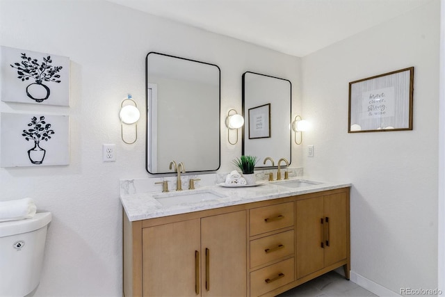 1815 Ingalls St, Lakewood, CO 80214 - bathroom featuring toilet, double vanity, and baseboards