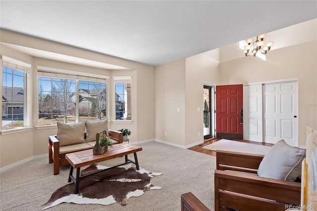 living room featuring a chandelier, carpet flooring, and baseboards