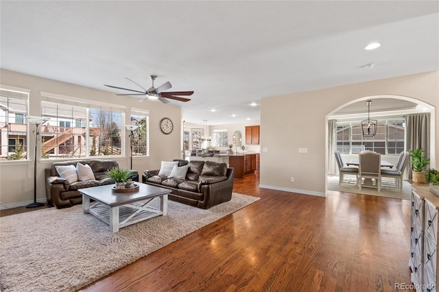 living area with ceiling fan, arched walkways, recessed lighting, dark wood-style flooring, and baseboards