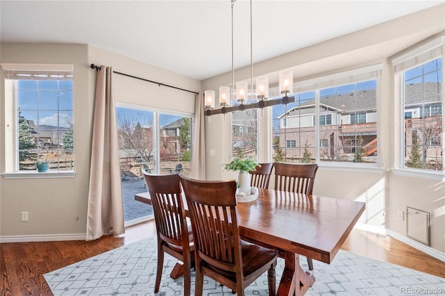 dining room with a chandelier, wood finished floors, and baseboards