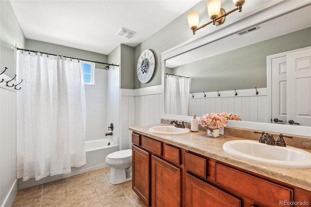 full bathroom featuring a wainscoted wall, visible vents, and a sink