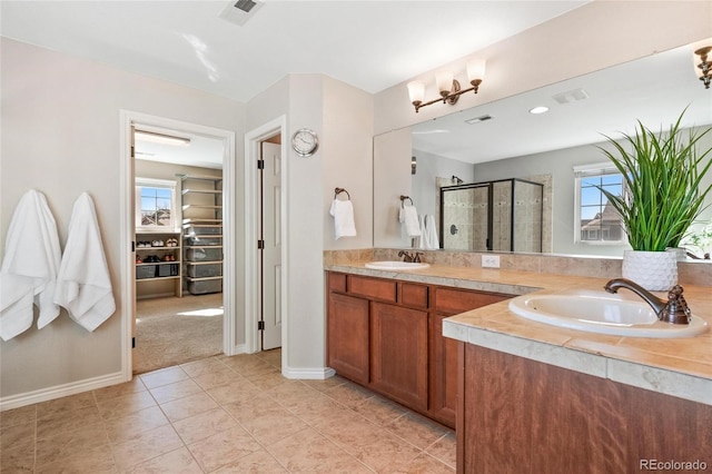 bathroom with a stall shower, visible vents, and a sink