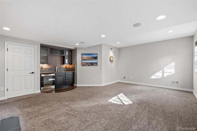 interior space featuring visible vents, wet bar, dark carpet, and recessed lighting