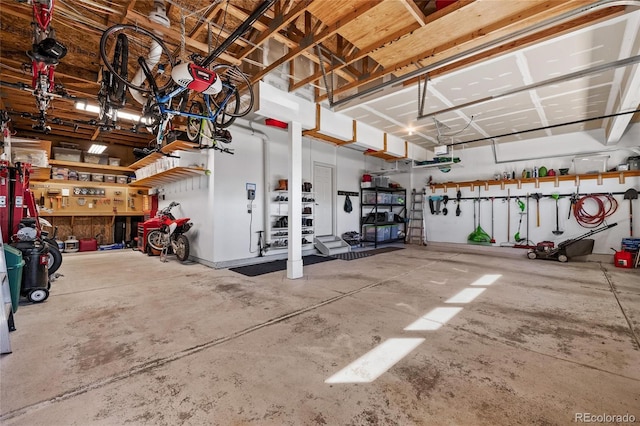 garage with a garage door opener and a workshop area