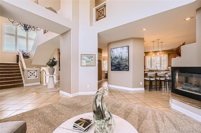 6961 Salvia St, Arvada, CO 80007 - living room with tile patterned floors, stairway, a chandelier, a high ceiling, and recessed lighting