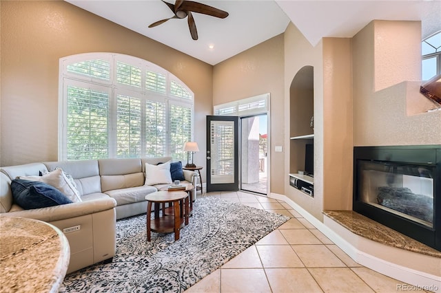 6961 Salvia St, Arvada, CO 80007 - living area featuring a towering ceiling, built in shelves, healthy amount of natural light, a ceiling fan, and light tile patterned floors
